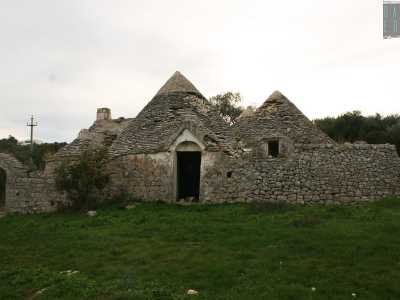 ...punteggiato da due grandi trulli in stato di abbandono su cui capeggiano ben quindici coni